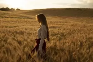 Ženska, ki izvaja čuječnost med žitnimi klasi, simbolizira sprostitev in osredotočenost v psihoterapiji